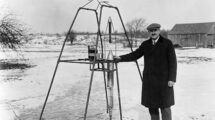 Robert H. Goddard standing beside the first liquid-fueled rocket in Auburn Massachusetts in 1926