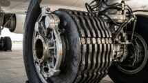 Close-up of carbon fiber aircraft brakes on a massive Boeing 777 landing gear.