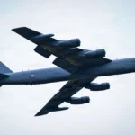 US Air Force B-52 Stratofortress heavy bomber with LA tail code soaring through a cloudy sky.