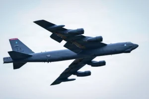 US Air Force B-52 Stratofortress heavy bomber with LA tail code soaring through a cloudy sky.