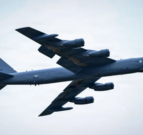 US Air Force B-52 Stratofortress heavy bomber with LA tail code soaring through a cloudy sky.