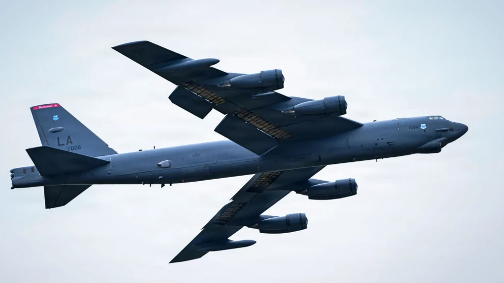US Air Force B-52 Stratofortress heavy bomber with LA tail code soaring through a cloudy sky.